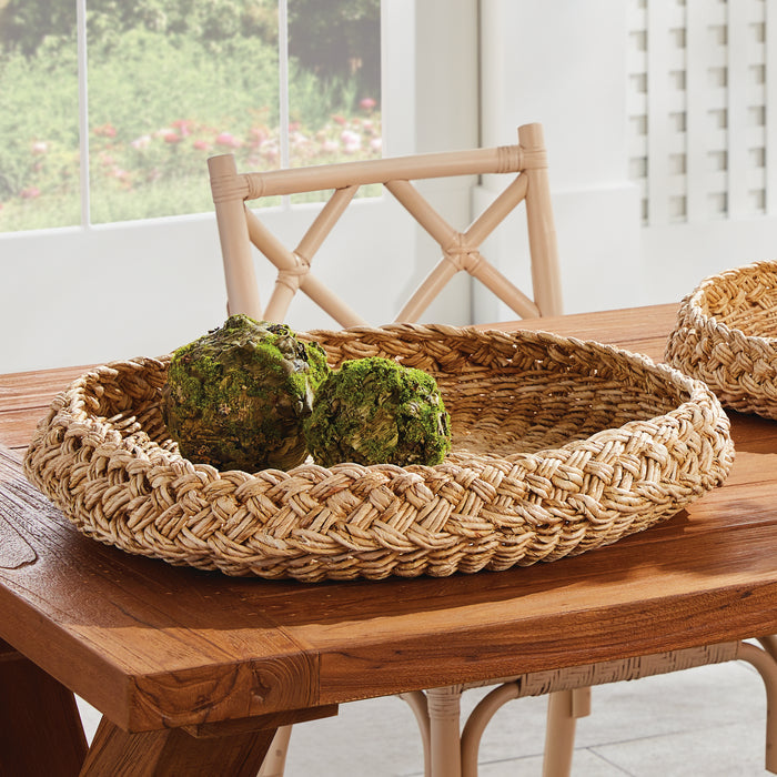 Woven baskets with green decorative items on a wooden table