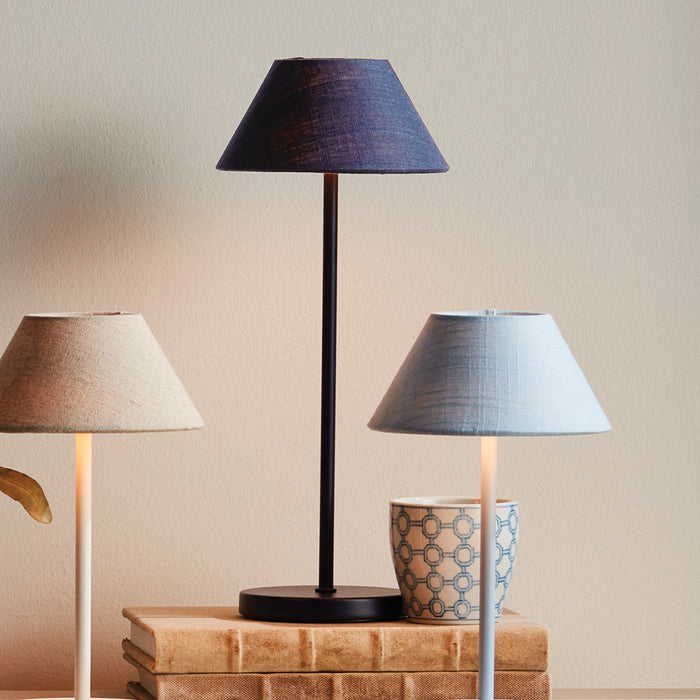 Alix Navy Linen and Light Blue Linen Rechargeable Lamps on book stack